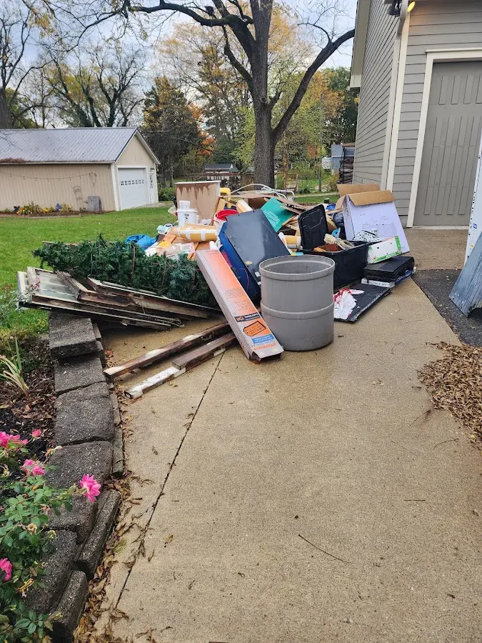 Dumpster being loaded with debris for Estate Cleanout Dumpster Rental in Tupper Lake